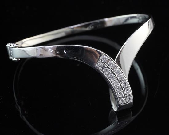 A 14ct white gold and diamond herringbone shaped hinged bangle,